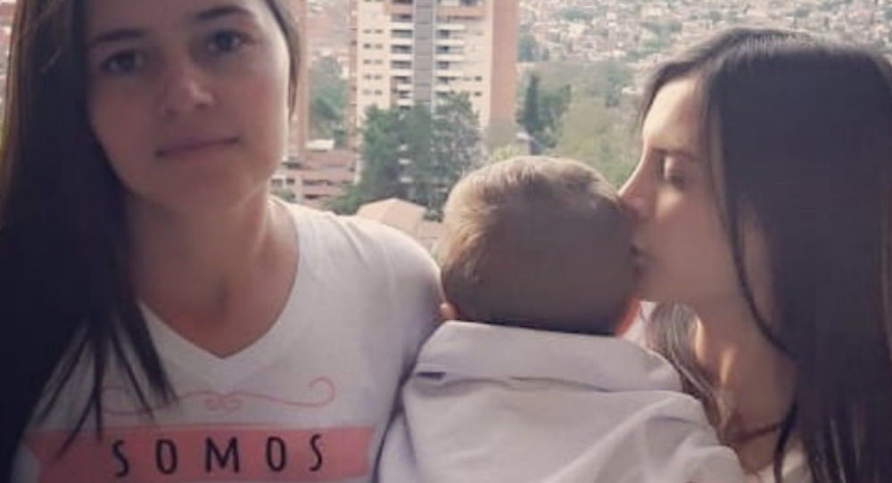 Two women baptise their child in Medellín Catholic church